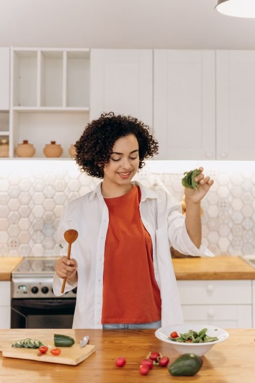 Mujer preparando vegetales frescos en su cocina