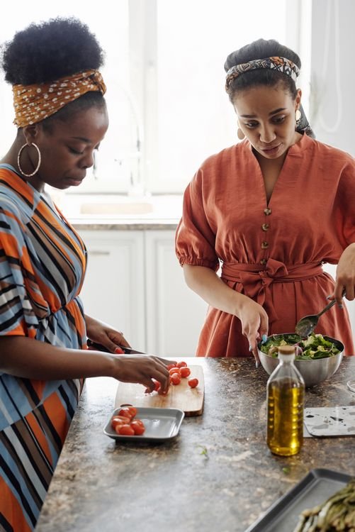 Dos mujeres preparando una ensalada juntas